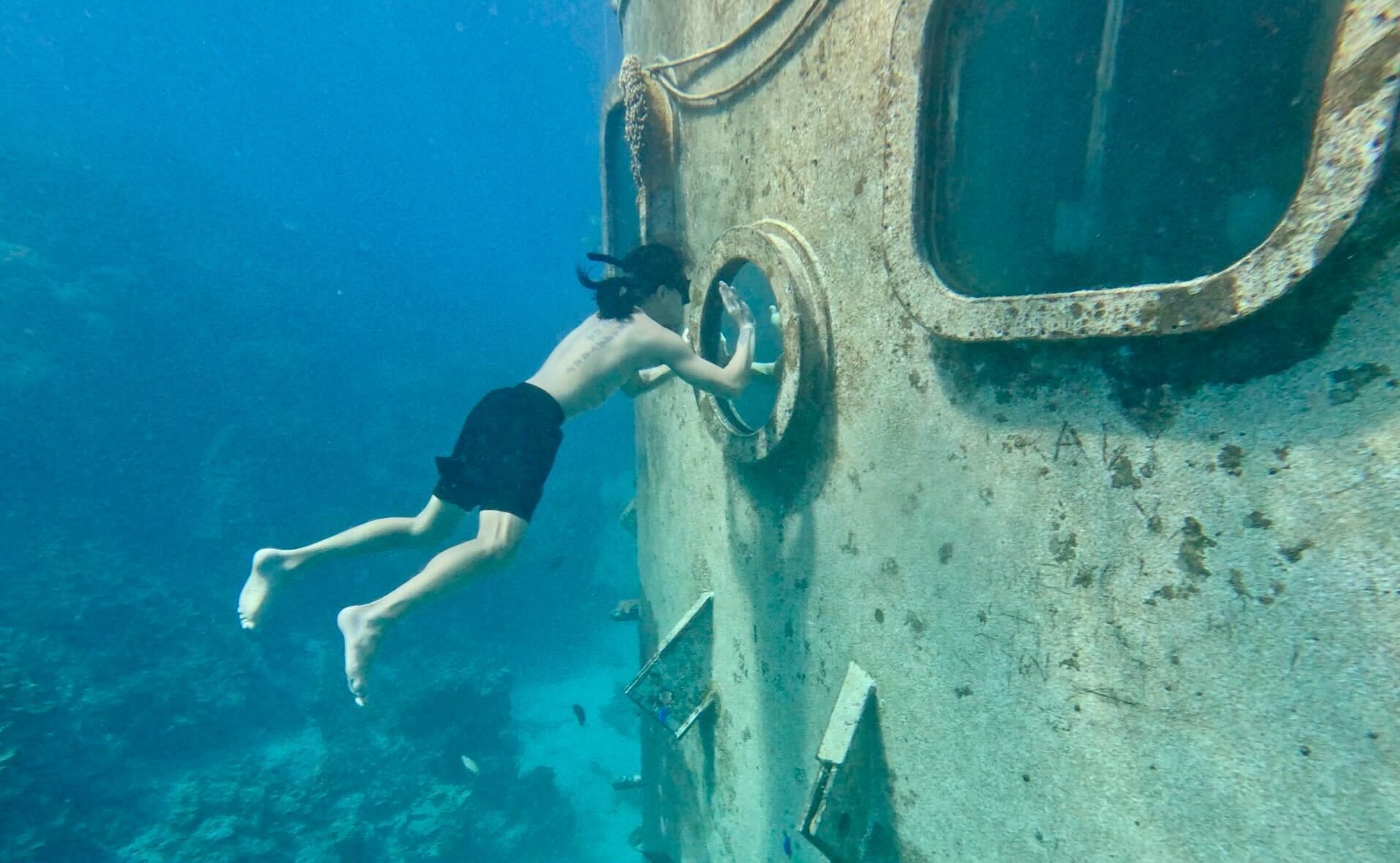 Freediving toward a wreck porthole